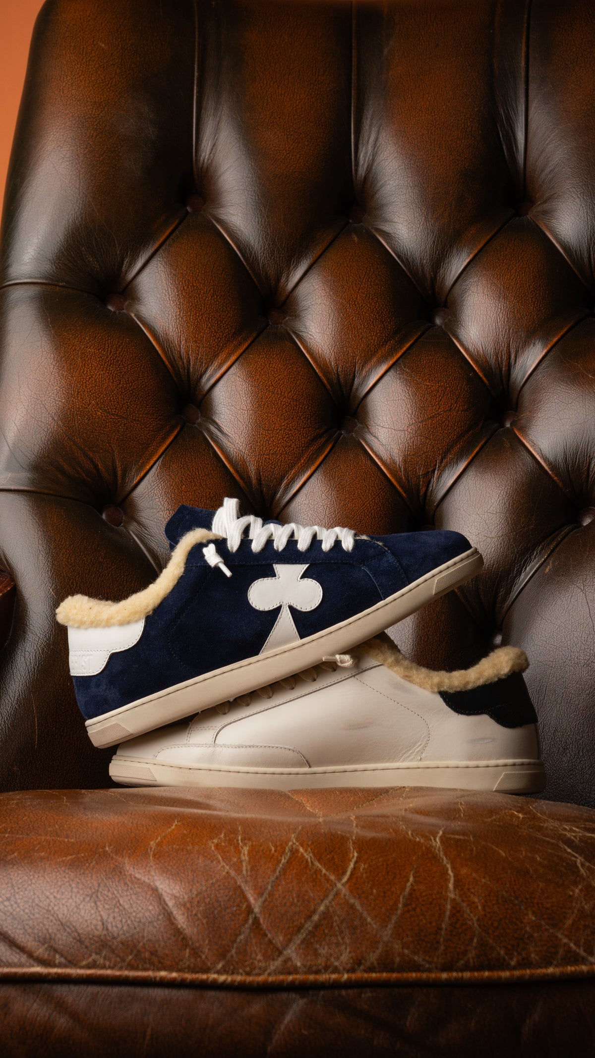 Geneva Wool Dark Blue stacked with Black Heel on a chesterfield chair