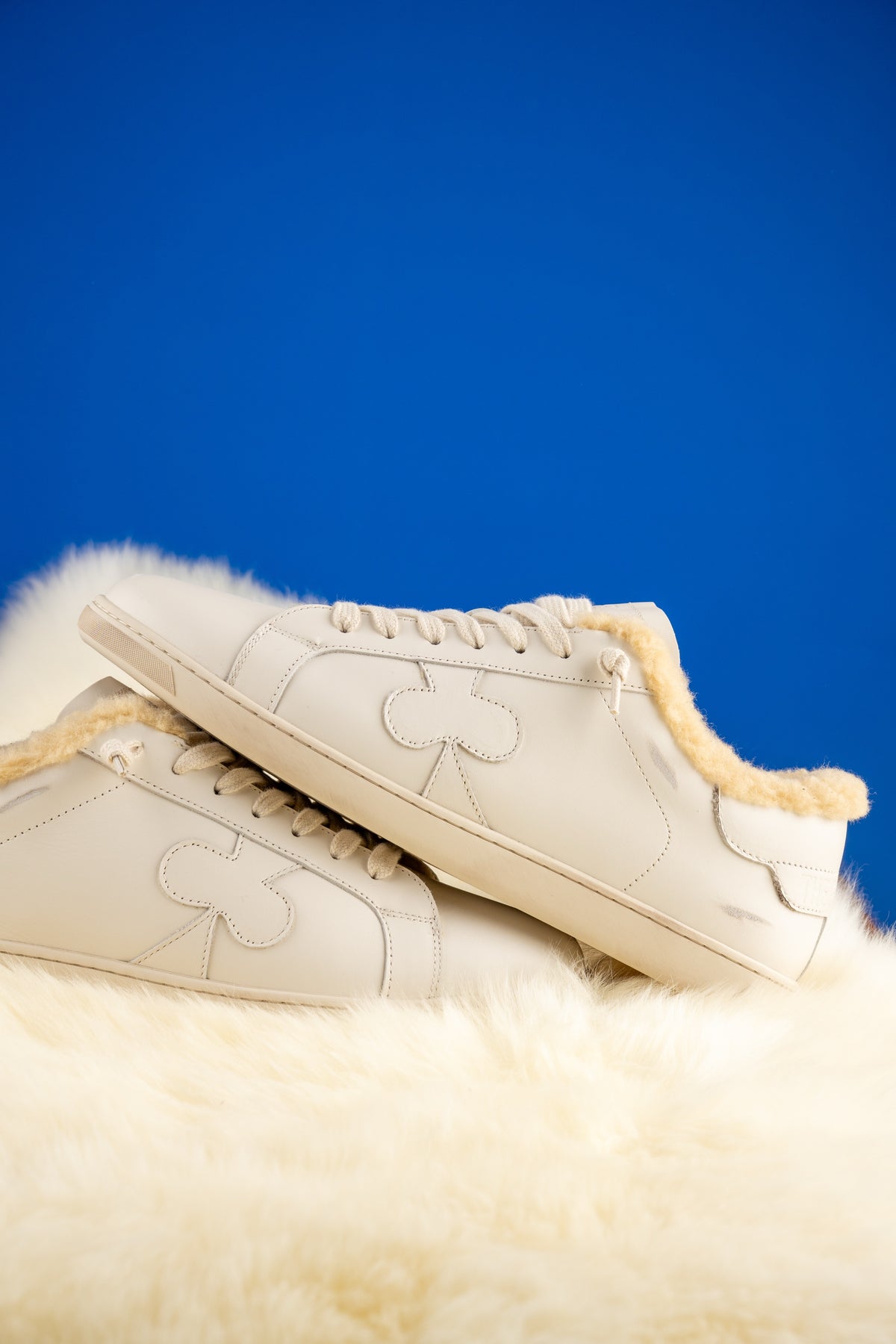 Geneva Wool Whiteout, pair on sheepskin against a blue backdrop