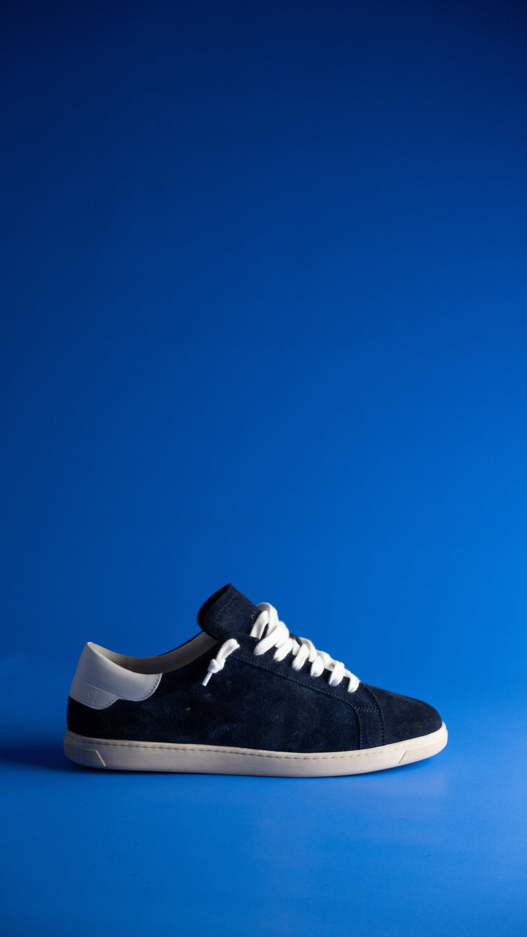 Geneva Dark Blue Unsigned, side view against a blue backdrop