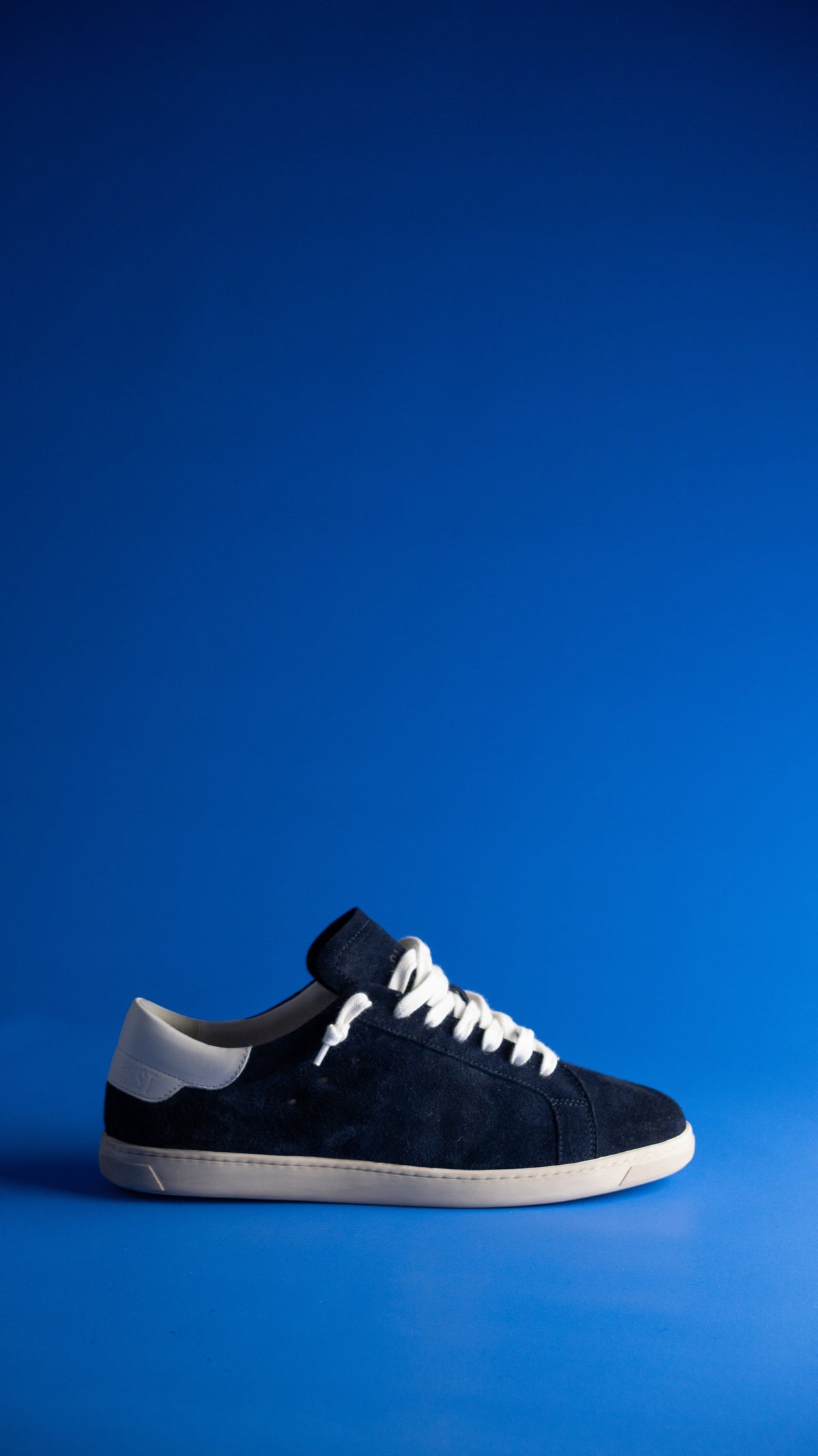 Geneva Dark Blue Unsigned, side view against a blue backdrop