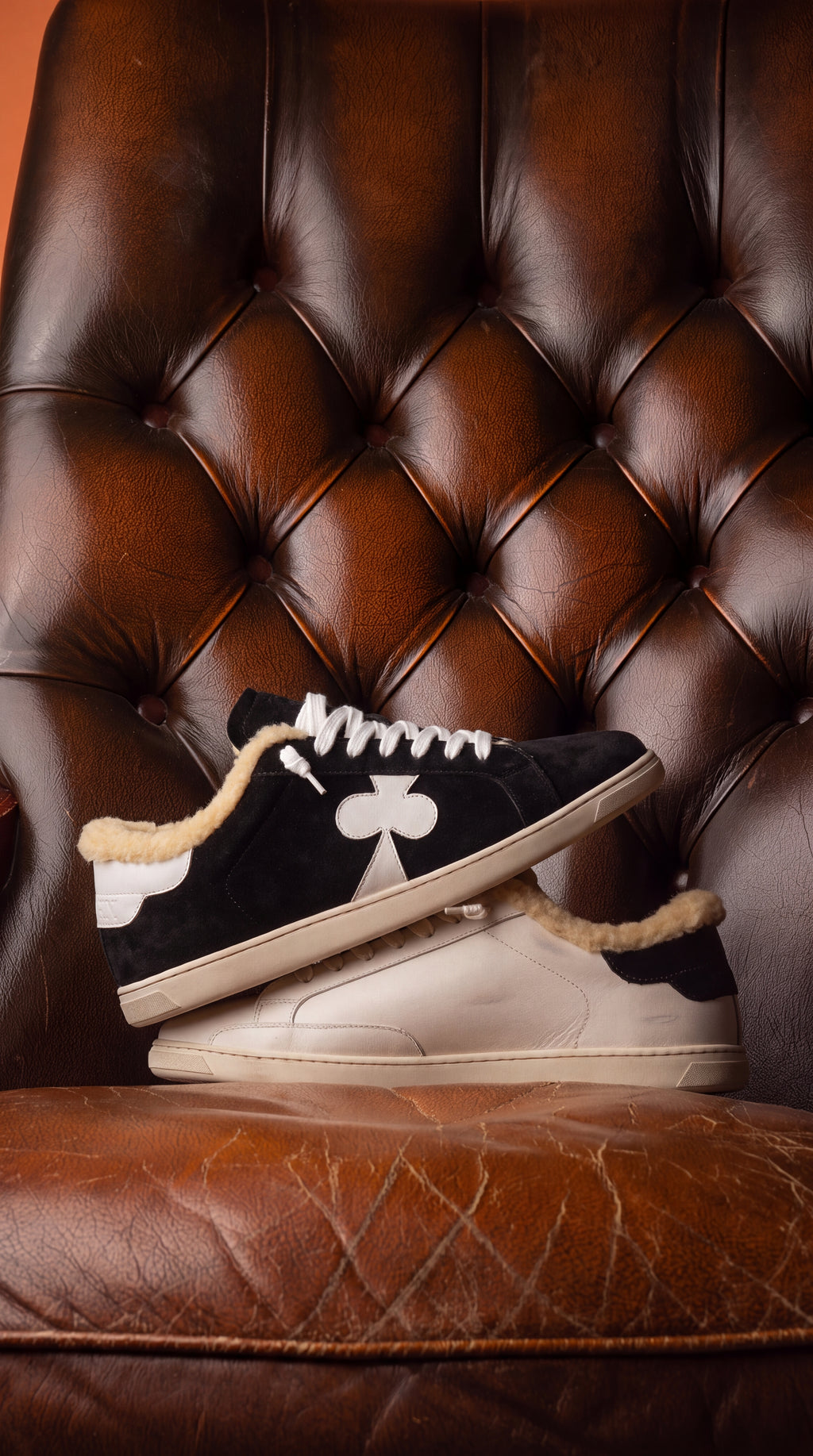 Geneva Wool Black Suede, stacked on a chesterfield chair