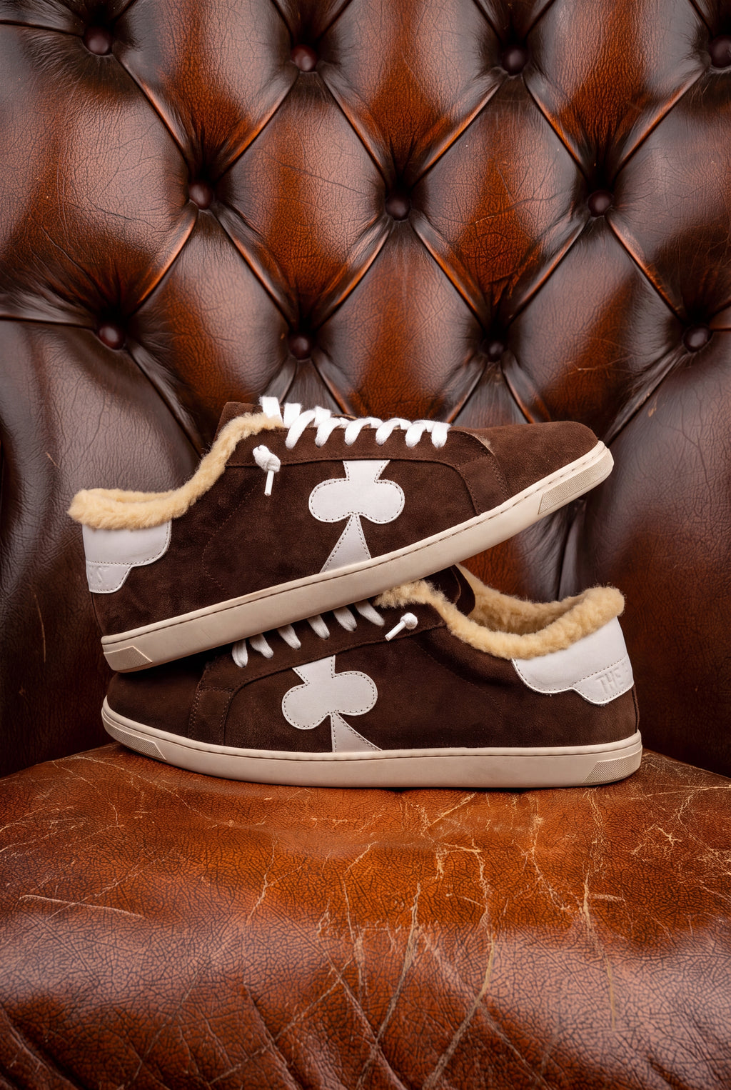 Geneva Wool Chocolate Suede, pair stacked on a chesterfield chair