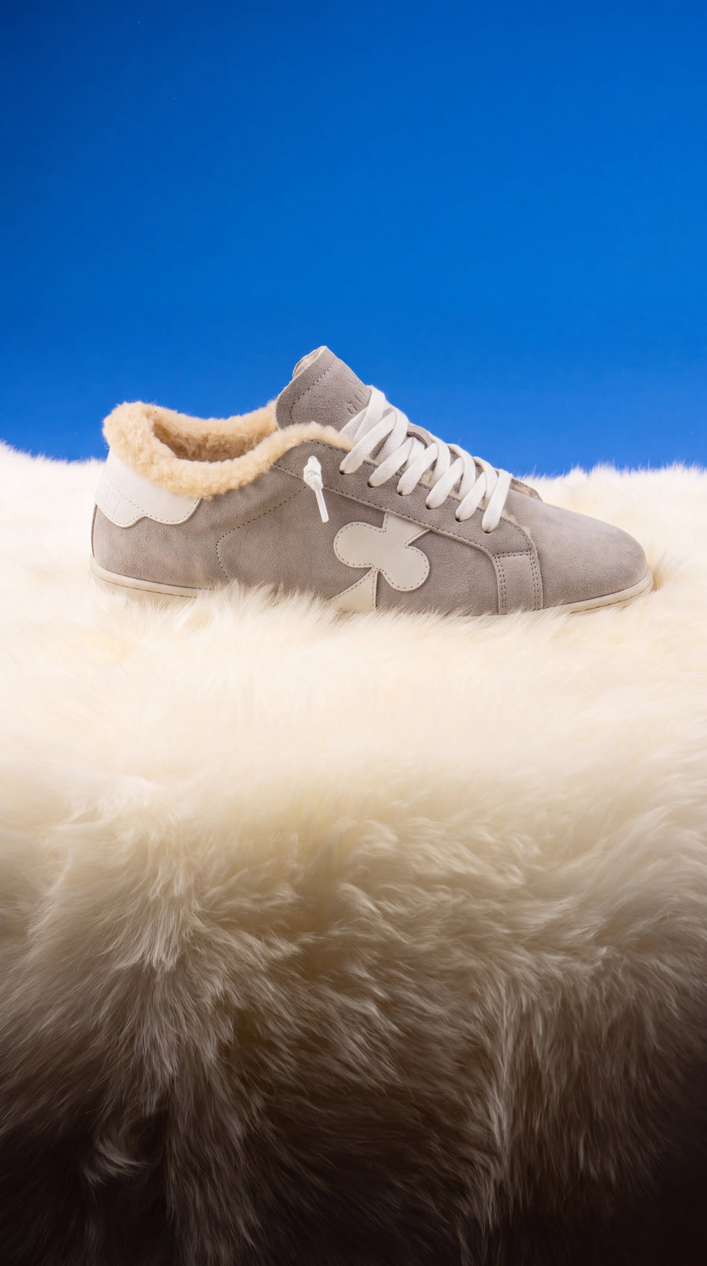 Geneva Wool Grey Suede, on sheepskin against a blue backdrop