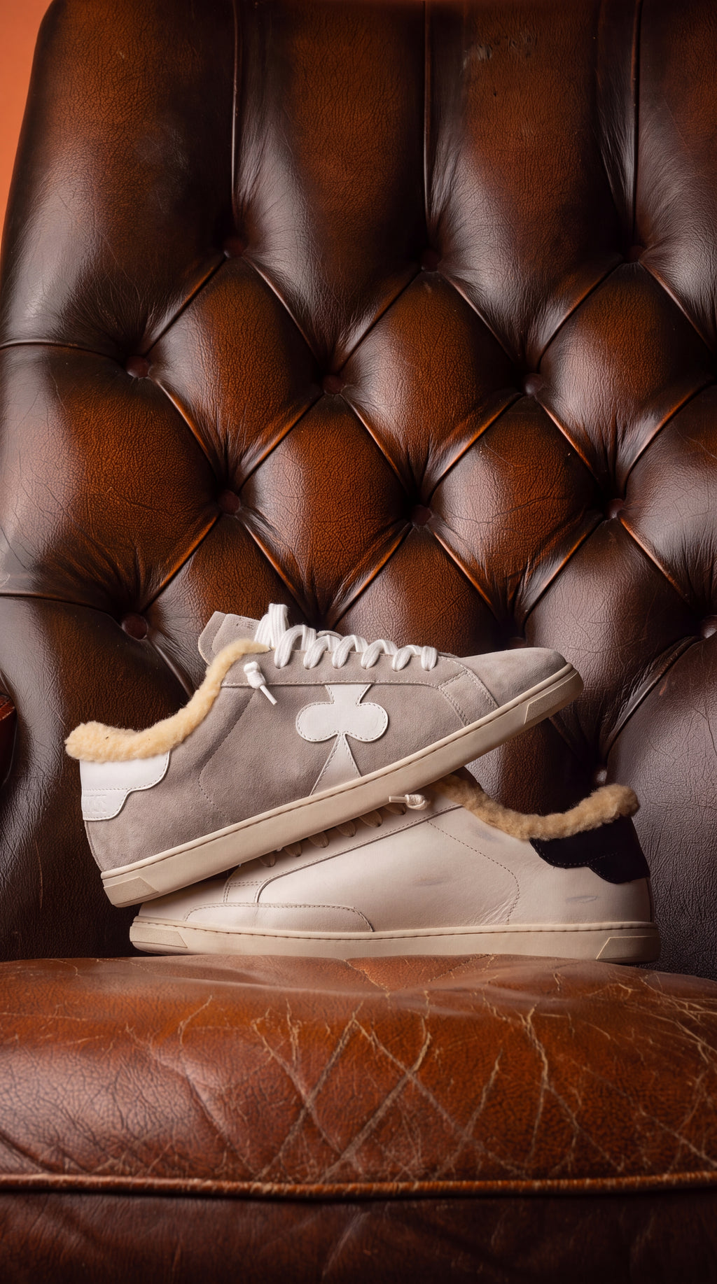 Geneva Wool Grey Suede, stacked on a chesterfield chair