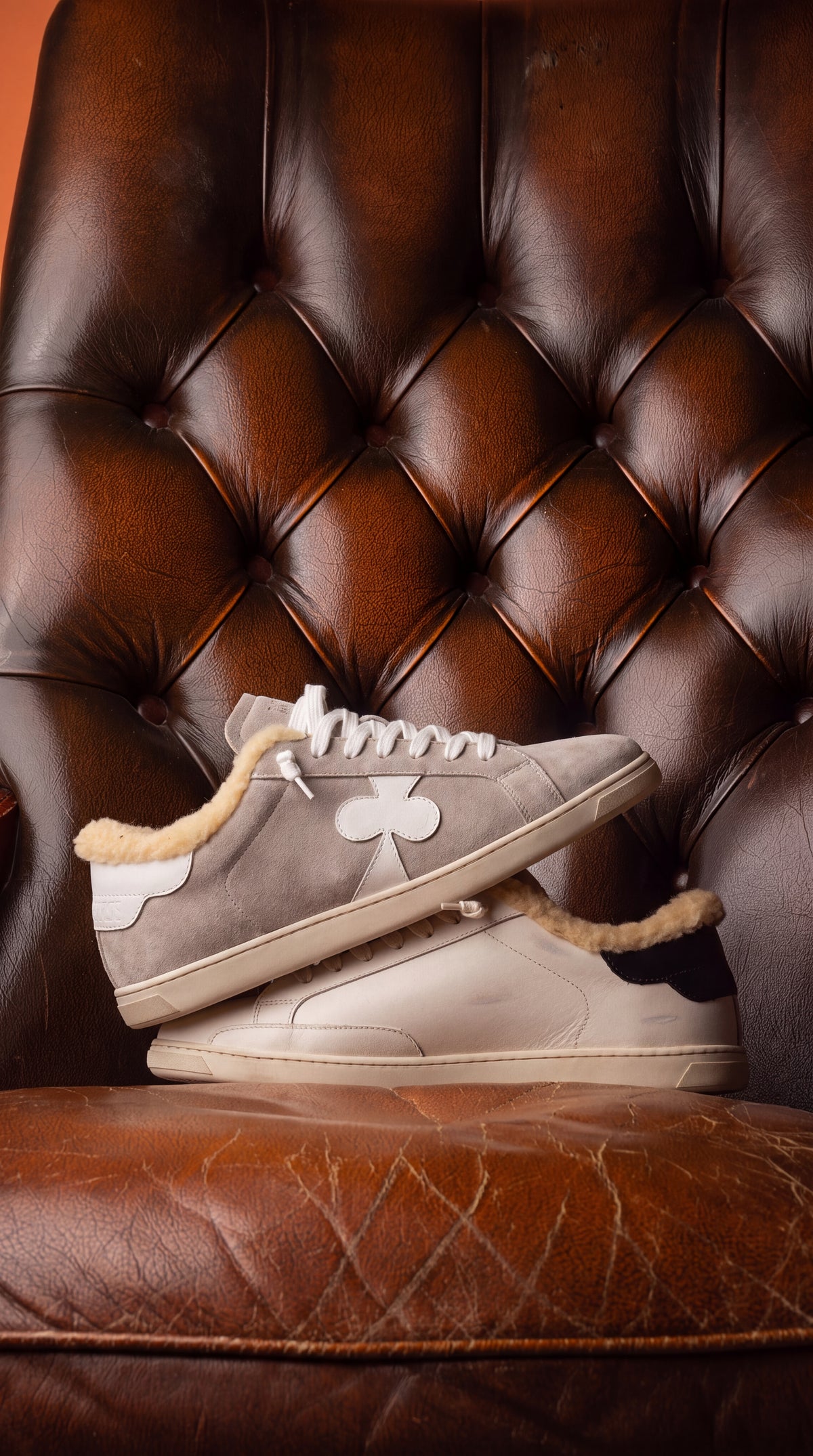 Geneva Wool Grey Suede, stacked on a chesterfield chair
